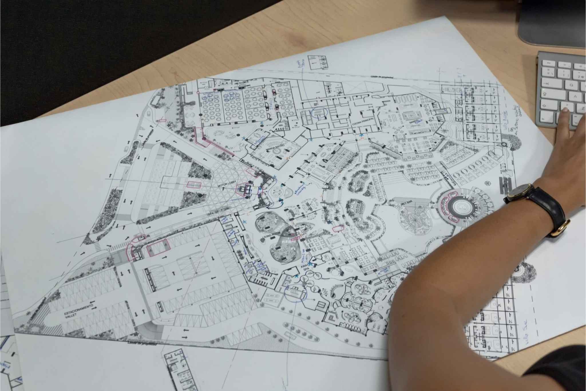 Plano arquitectónico en mesa de trabajo, con detalles de distribución y señalización, revisado por un diseñador de Sign Factory, empresa especializada en producción e instalación de letreros y señalética en Cancún.